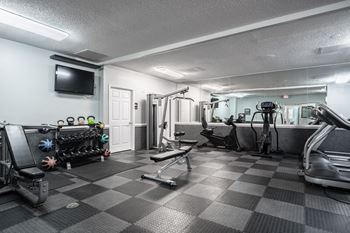 A well-equipped gym with a variety of exercise machines and weights.